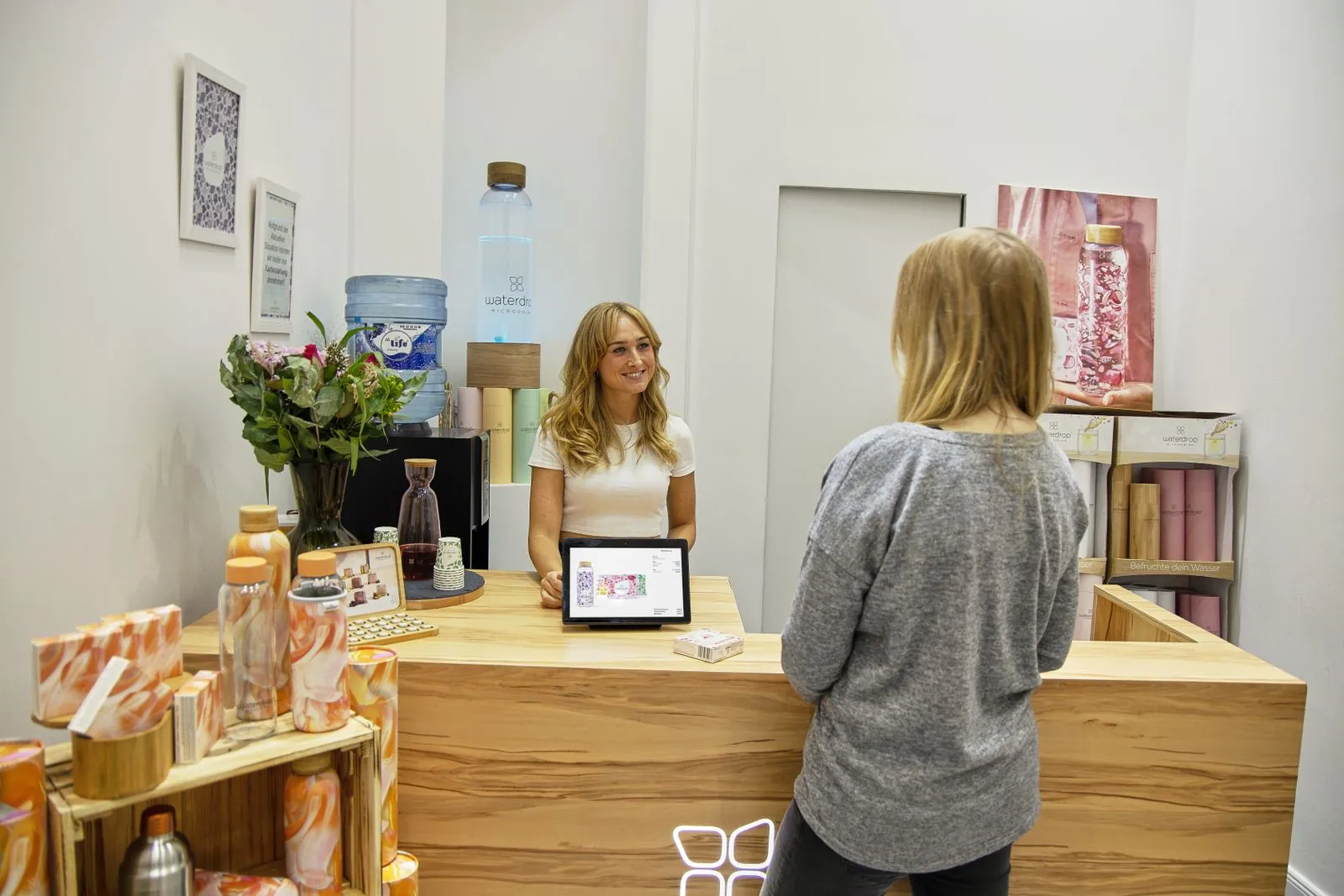 Receptionist smiling while welcoming a client at a med spa front desk